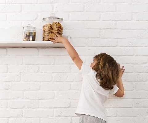 Kid stealing a cookie from cookie jar